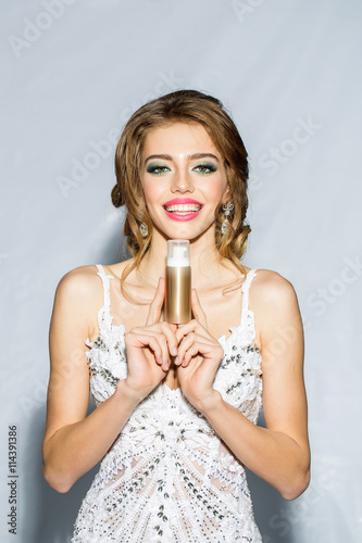 Woman in white dress with makeup flask