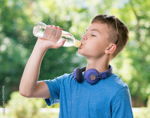 Teen boy drinking water