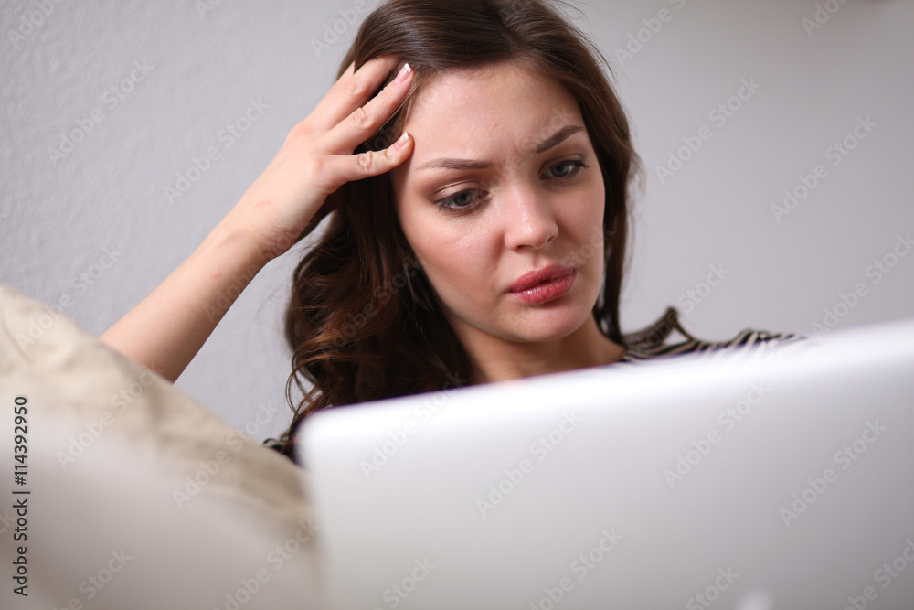 Happy pretty woman using laptop sitting on sofa Happy pretty woman using laptop sitting on sofa