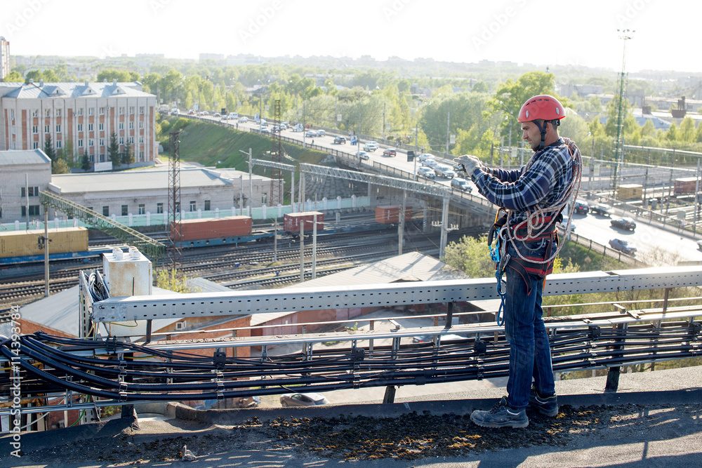 quality control. worker finished work and takes photos for the report. tower technician installed telecommunication equipment on the roof of the building quality control. worker finished work and takes photos for the report. tower technician installed telecommunication equipment on the roof of the building