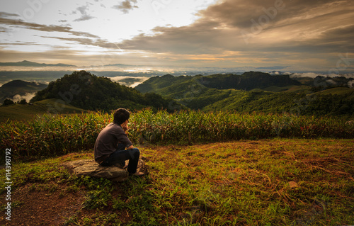 Man sit on the Rock for View the Hills and Wait sunset, Nan , Thailand