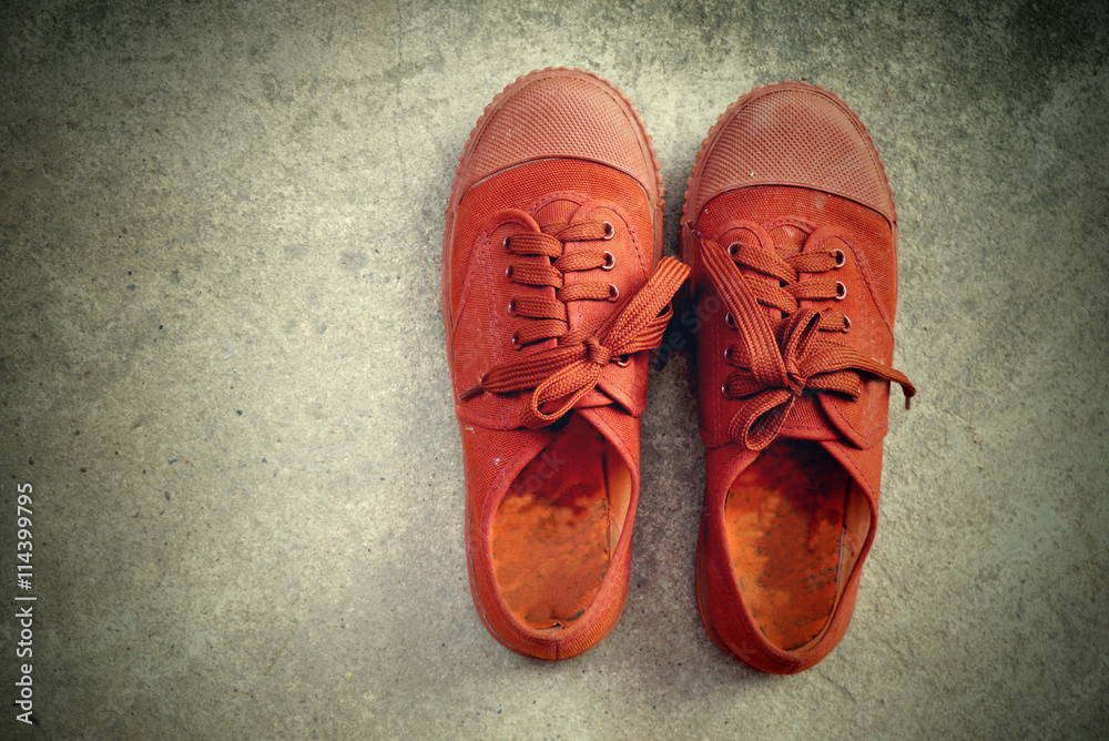 pair of old brown shoes for school on cement background, vintage tone
