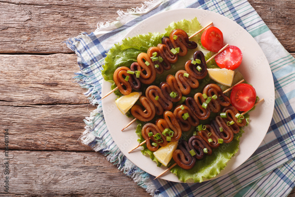 Grilled squid on skewers with vegetables close-up. horizontal top view
Grilled squid on skewers with vegetables close-up. horizontal top view