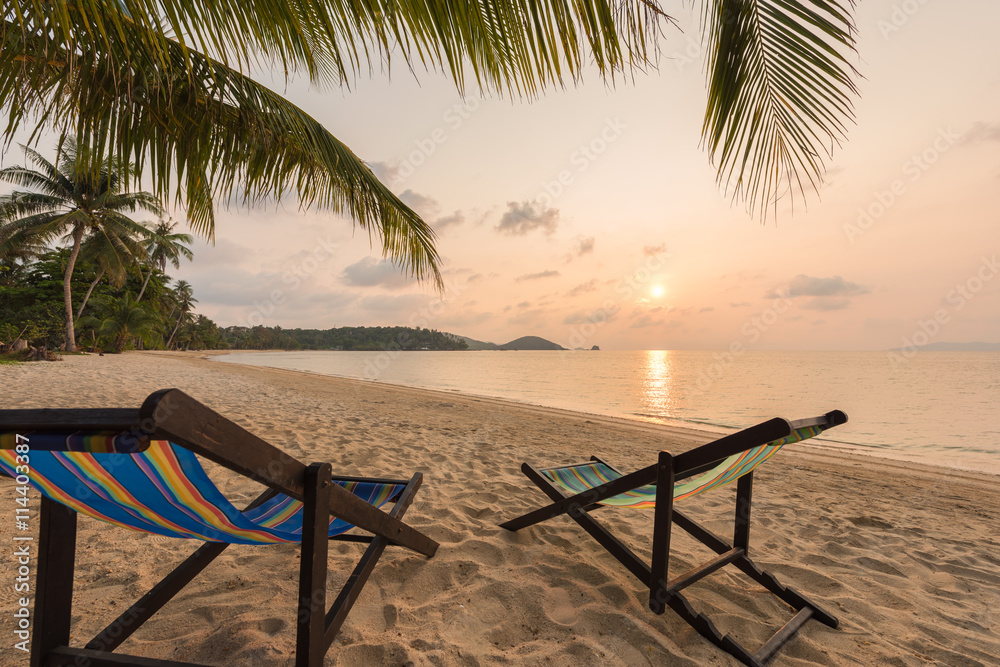 Beach chairs on the sand beach, Beautiful beach and tropical sea at sunset.