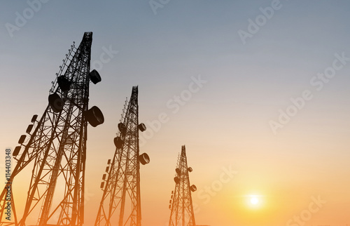Silhouette, telecommunication towers with TV antennas and satellite dish in sunset photo
