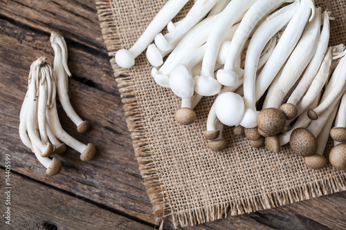 shimeji mushrooms on sackcloth and wooden background photo