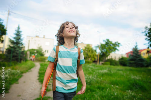 The schoolboy comes back from school in good mood.