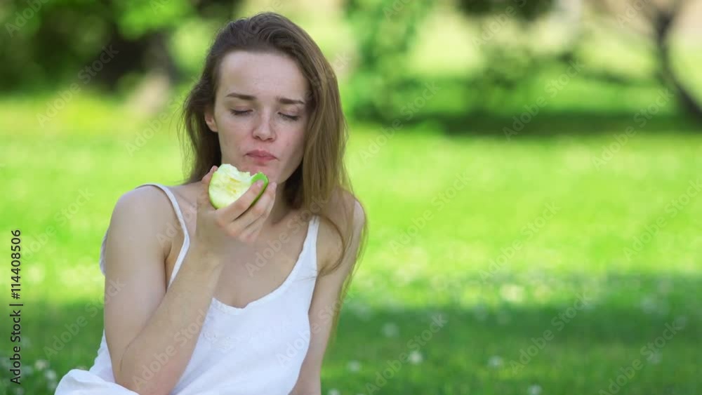Young woman biting and eating tasty green apple Young woman biting and eating tasty green apple