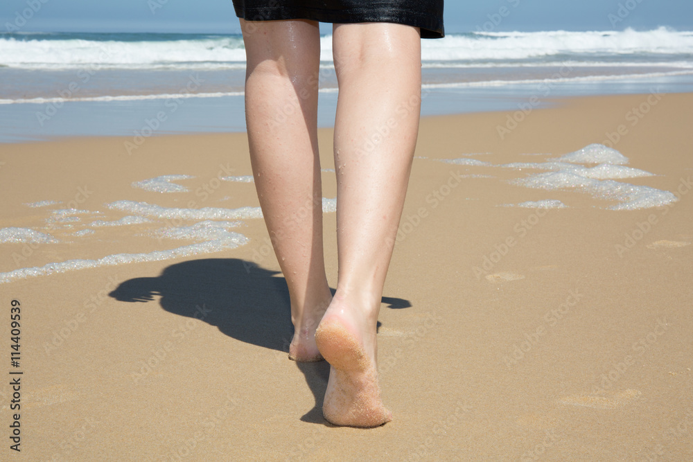 Woman walking on sand beach leaving footprints in the sand. Woman walking on sand beach leaving footprints in the sand.