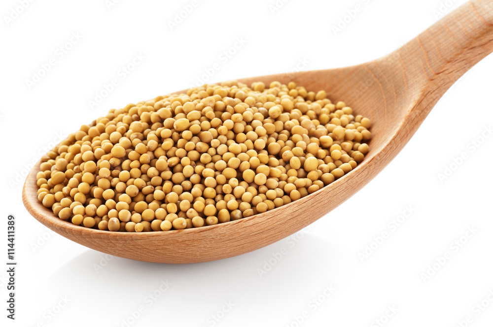 Mustard seeds on wooden spoon isolated on white background. Mustard seeds on wooden spoon isolated on white background.