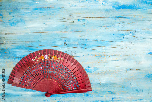 Spanish fan on blue wooden background