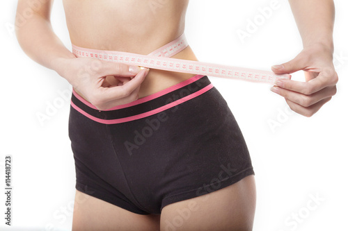 Woman measuring her slim body on white background