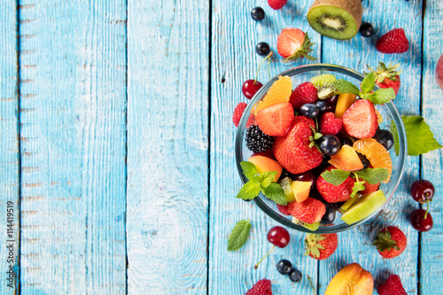 Fresh fruit salad served on wooden table photo