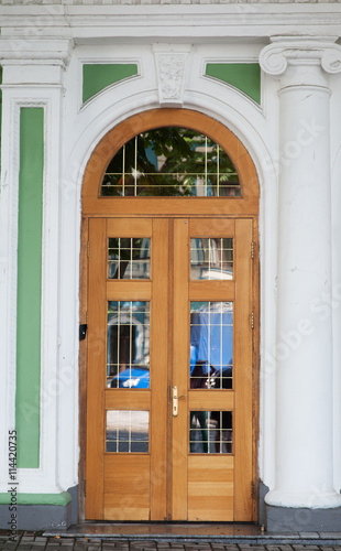 Ornate stained wood doors with wrought iron grating over glass windows