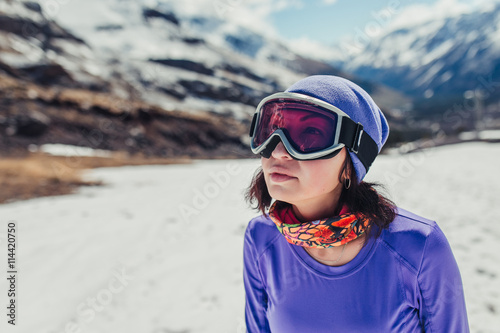 Happy girl dressed in ski or snowboard fashion mask goggles. Mountain landscape. Extreme adventure. Winter ski resort