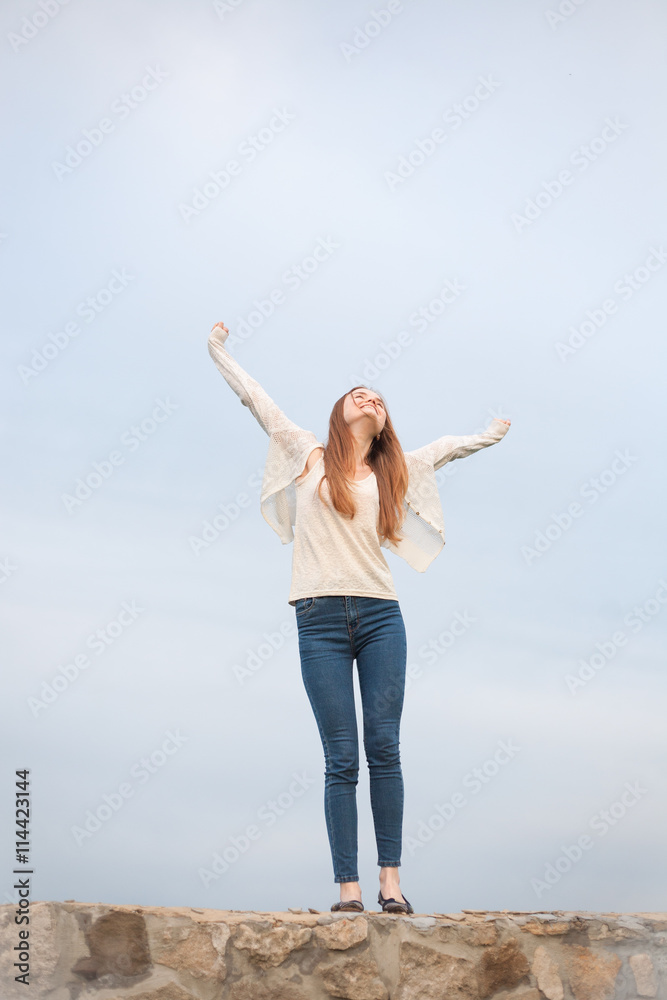woman with open arms in the sky background at the morning. woman with open arms in the sky background at the morning.
