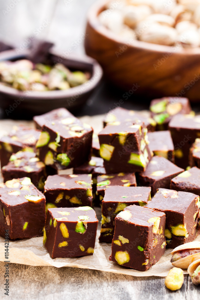 Dark  chocolate cubes with pistachios on wooden background
