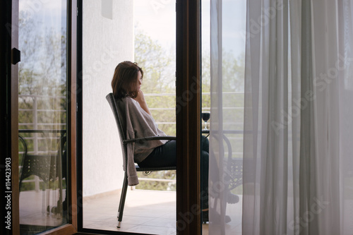 Free Download Young beautiful woman in a sweater sitting on a cozy terrace with a glass of red wine - GFXLoad