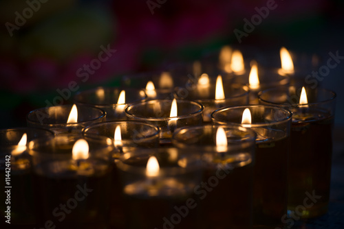 Candles lights in a Buddhist temple closeup photo