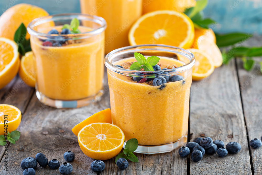 Orange and mango smoothie with granola and berries Orange and mango smoothie with granola and berries