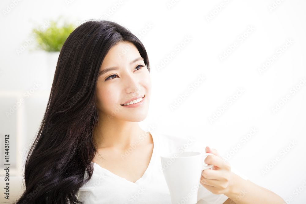 smiling young woman drinking coffee in living room smiling young woman drinking coffee in living room