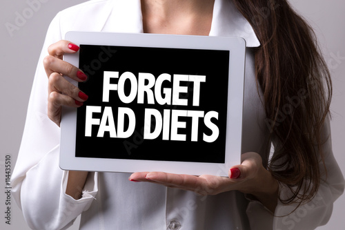 Female doctor holding a tablet with the text: Forget Fad Diets
