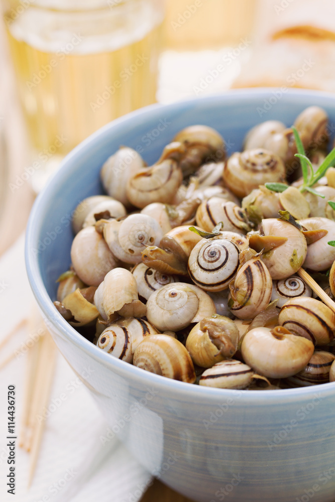 snails in blue bowl with glass of beer snails in blue bowl with glass of beer