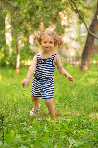 Baby toddler running on green lawn
