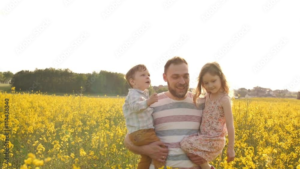 Father holds on hands his son and daughter Slow mo Father holds on hands his son and daughter Slow mo