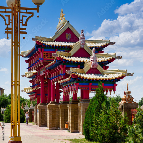 the magnificent gate of the Palace Buddha-red color with carved roofs against bright blue sky