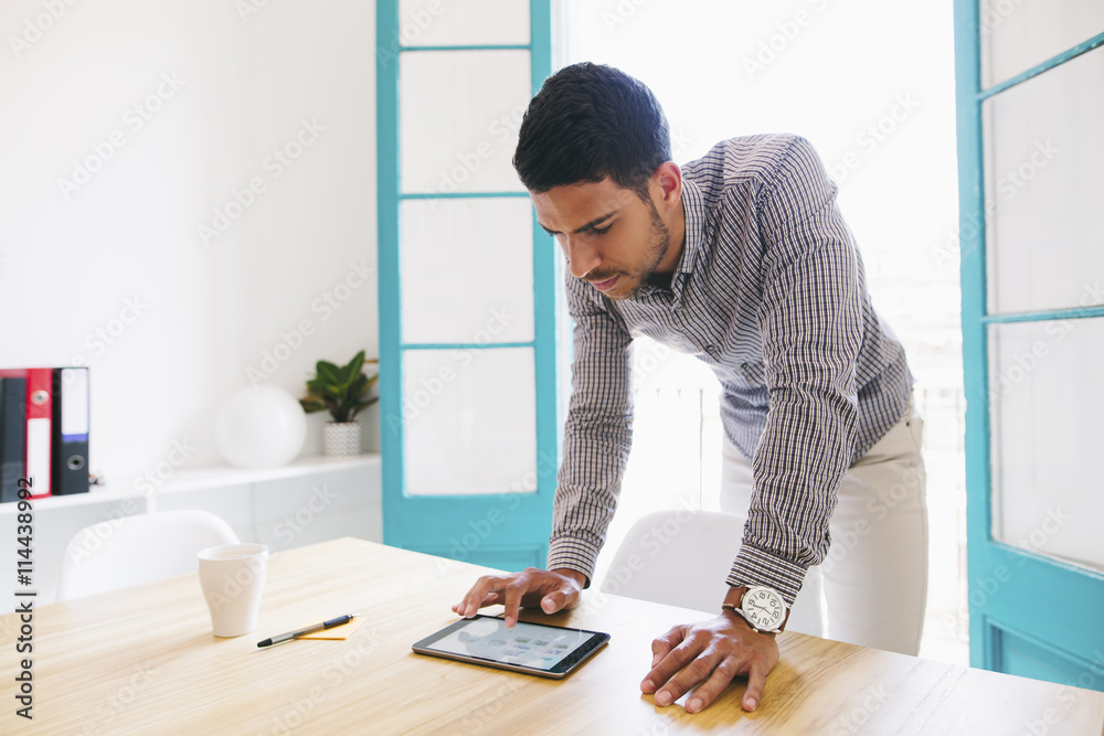 Young businessman using digital tablet in office Young businessman using digital tablet in office