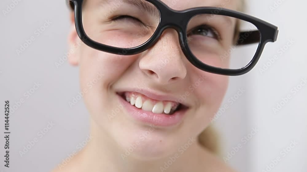 young girl with nerd glasses pointing with the finger to the side
