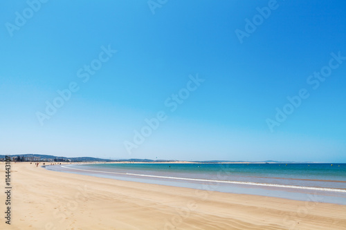 Clear blue sky over emerald sea and yellow sandy beach, Agadir, Morocco photo