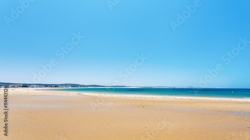 Clear blue sky over emerald sea and yellow sandy beach, Agadir, Morocco