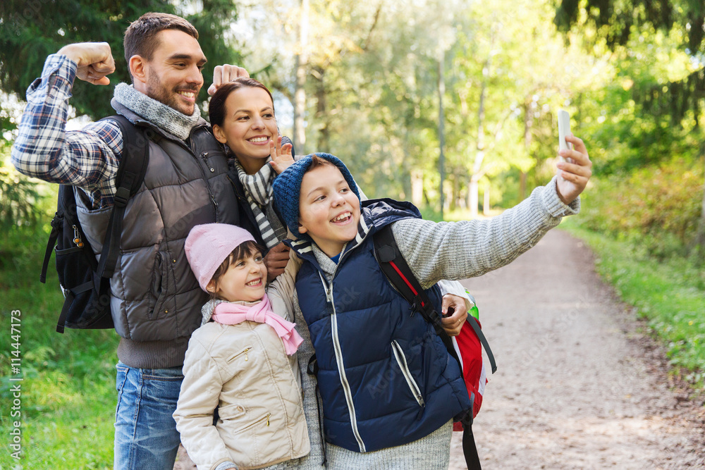 family with backpacks taking selfie by smartphone family with backpacks taking selfie by smartphone