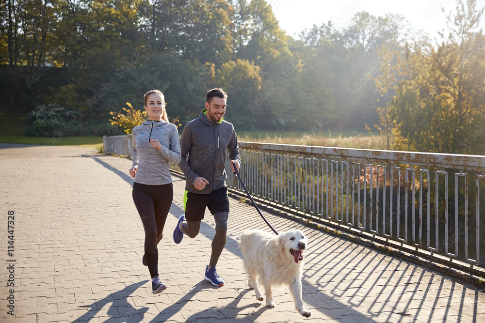 happy couple with dog running outdoors happy couple with dog running outdoors