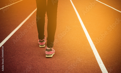 Woman walking on running track. Vintage tone.