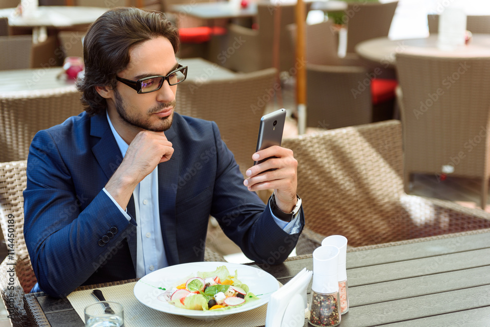 Busy man having breakfast in restaurant