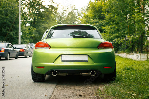Green car in the summer is on the sidelines of the road