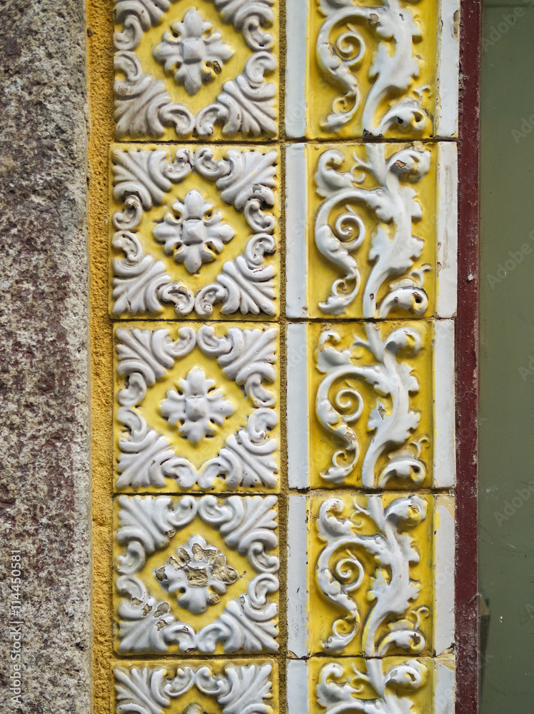 A piece of an old yellow floral ceramic tile in Portugal on the