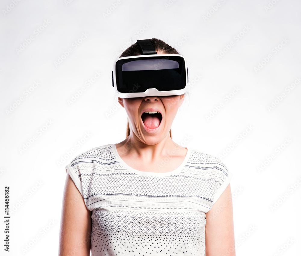 Woman with virtual reality goggles. Studio shot, gray background Woman with virtual reality goggles. Studio shot, gray background