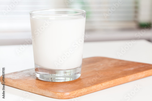 A glass of milk on an office desk. Selective focus.