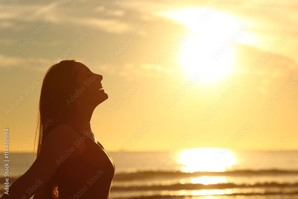 Profile of woman breathing fresh air at sunset