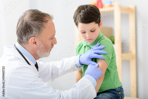 Doctor pediatrician injecting vaccine