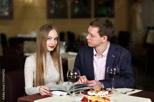 Cheerful couple with menu in a restaurant. © davit85