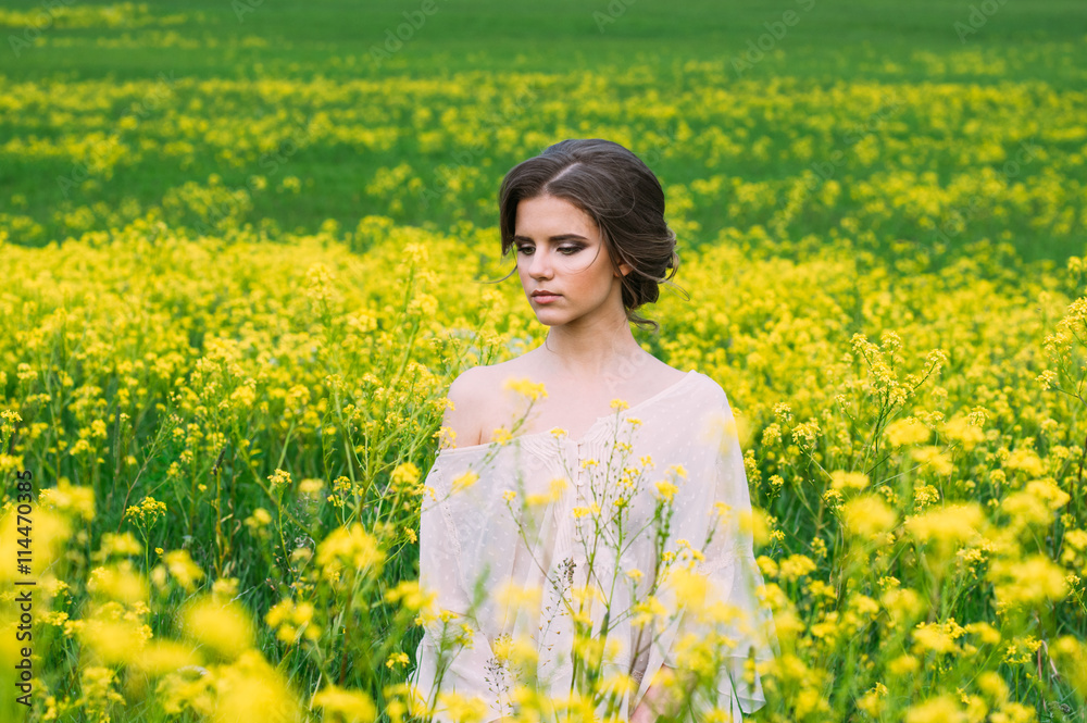 Portrait of young beautiful girl in field with yellow flowers Portrait of young beautiful girl in field with yellow flowers