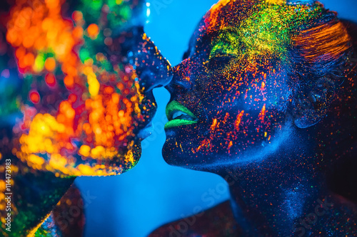 People are colored fluorescent powder. a pair of lovers dancing photo