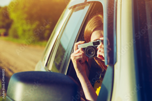 girl taking photo with camera moving in car