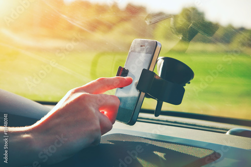 hand using smart phone as gps navigation while car driving photo