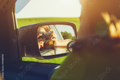 smiling girl taking photo with camera moving in car © Ivan Kruk
